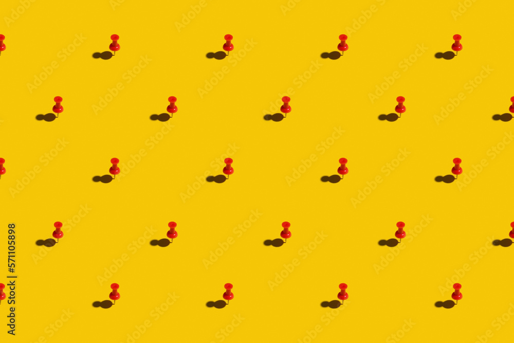 Red push pins on a yellow background Red push pins on a yellow background