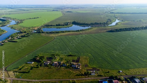 view from a height to the green fields of crops, the pond for irrigation, the sun's glare and tinting, © Антон Скрипачев