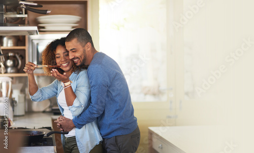 Obraz na plátně Cooking, black couple and hug in a kitchen with marriage and love at home with mockup