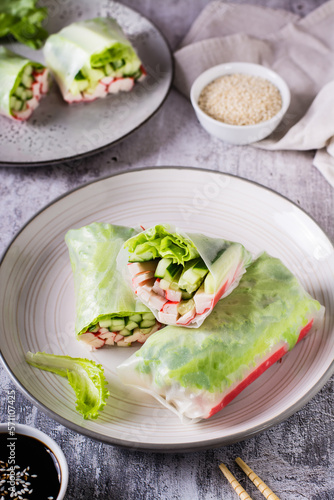 Fresh spring rolls with crab sticks, cucumber and lettuce. Vegetarian food. Vertical view