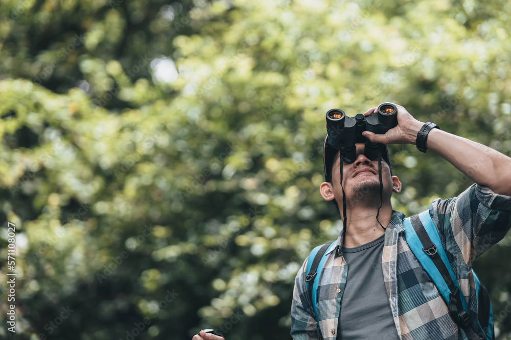 Hikers use binocular to see animals and view landscape with backpacks in the forest. hiking and adventure concept. Hikers use binocular to see animals and view landscape with backpacks in the forest. hiking and adventure concept.