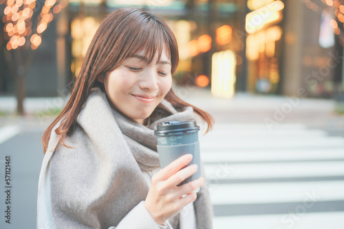 寒空の下珈琲を飲んで休憩する女性