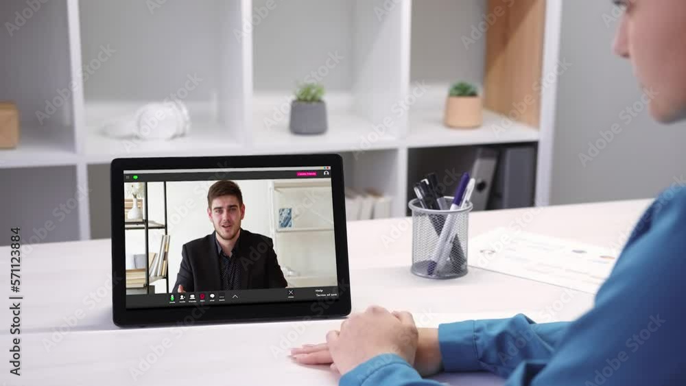 Video interview. Online meeting. Internet communication. Business woman watching listening male partner speaking on tablet at virtual office. Video interview. Online meeting. Internet communication. Business woman watching listening male partner speaking on tablet at virtual office.