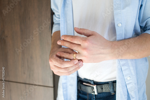 Photography A man removes a gold wedding ring from his left hand