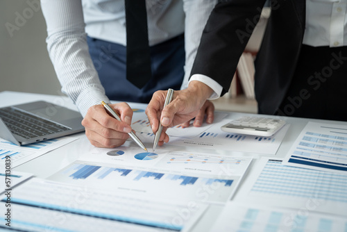 Asian businessmen and investors brainstorm applications for web design planning and develop templates, graphs, and calculations for mobile projects working together in the office.