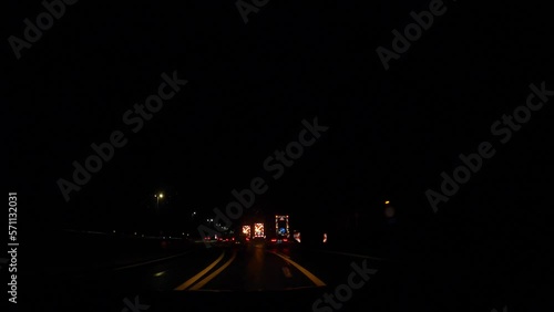 Traffic passing by highway construction at night. Cars driving in the dangerous area with flashing arrows. POV Hyperlapse photo