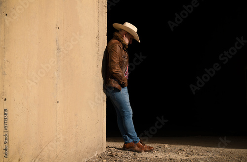 Portrait of adult man in cowboy hat against wall