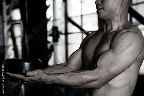 Sexy body of muscular young Asian man in gym. Concept of health care, exercise fitness, Strong muscle mass, body enhancement, fat reduction for men's health supplement product presentation.