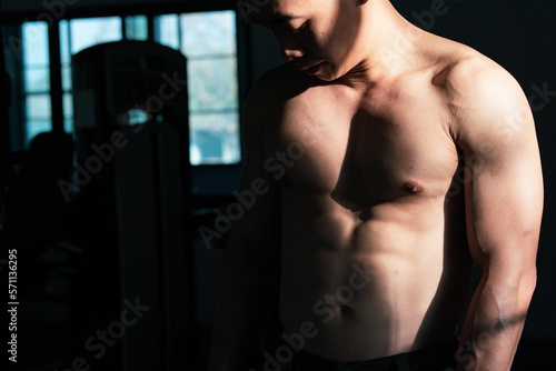Sexy body of muscular young Asian man in gym. Concept of health care, exercise fitness, Strong muscle mass, body enhancement, fat reduction for men's health supplement product presentation. © Midnight Studio v2