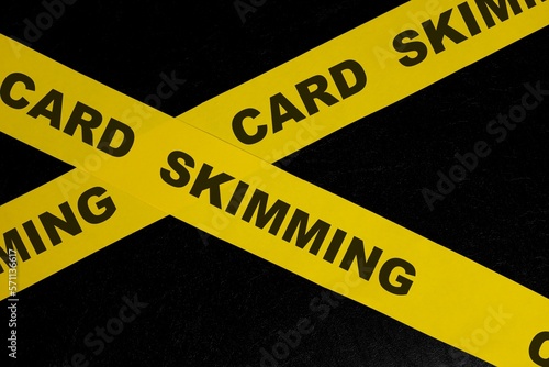 Obraz na płótnie Card skimming cybercrime and theft alert, caution and warning concept. Yellow barricade tape with word in dark black background. w salonie
