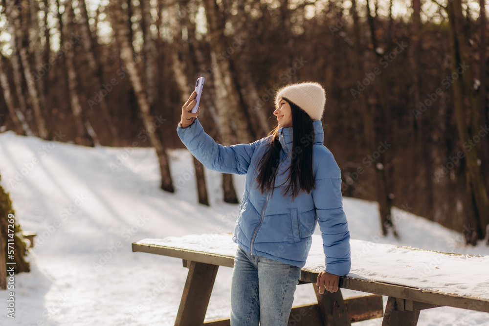 Young woman taking a selfie in winter holiday in park. Young woman taking a selfie in winter holiday in park.