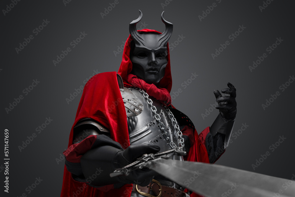 Portrait of evil knight with black mask pointing his sword to camera. Portrait of evil knight with black mask pointing his sword to camera.
