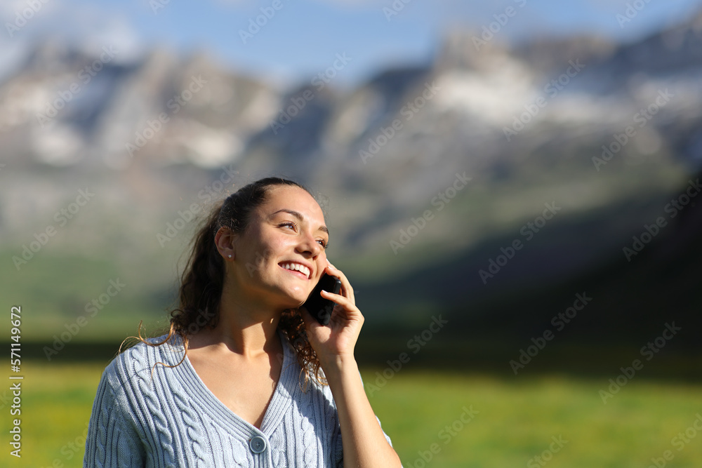 Happy woman talking on cell phone in nature Happy woman talking on cell phone in nature