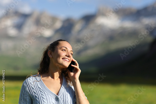 Happy woman talking on cell phone in nature