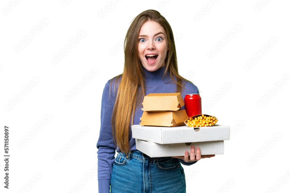Young pretty woman holding pizzas and burgers over isolated chroma key background with surprise facial expression Young pretty woman holding pizzas and burgers over isolated chroma key background with surprise facial expression