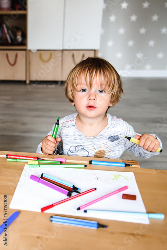 Little boy drawing with felt-tip pens photo