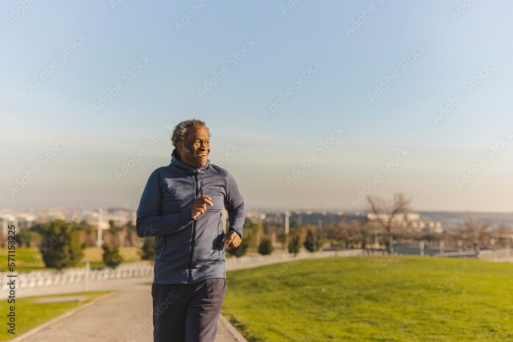 Senior man running in park on sunny day Senior man running in park on sunny day