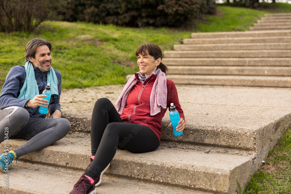 Mature couple with bottles sitting on steps Mature couple with bottles sitting on steps