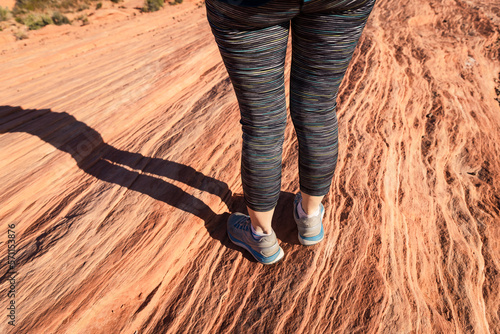 Athletic shoes walking along a rock formation in the desert photo