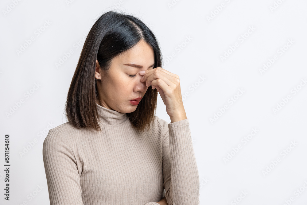 Portrait of beautiful young asian sick woman over isolated white background suffer from headache, thick nasal mucus, and face pain symptoms. Sinus,Sinusitis, or rhinosinusitis concept. Portrait of beautiful young asian sick woman over isolated white background suffer from headache, thick nasal mucus, and face pain symptoms. Sinus,Sinusitis, or rhinosinusitis concept.