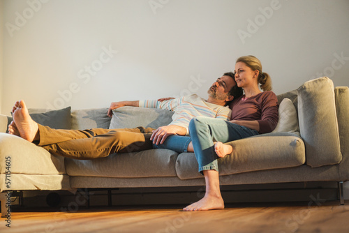 Mature couple spending leisure time resting on sofa at home