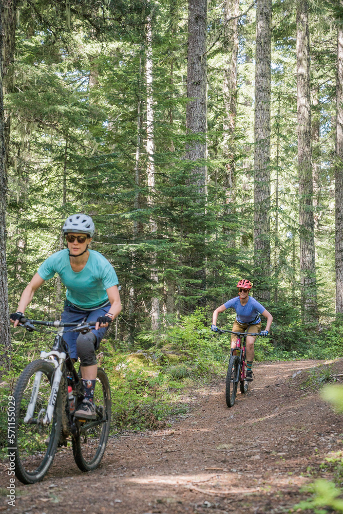 Two female bikers enjoy a trail in Sandy, OR near Mt. Hood. Two female bikers enjoy a trail in Sandy, OR near Mt. Hood.