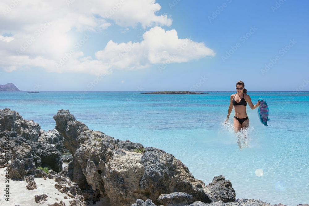 Landscape with woman at seaside beach rocks and turquoise clear Landscape with woman at seaside beach rocks and turquoise clear