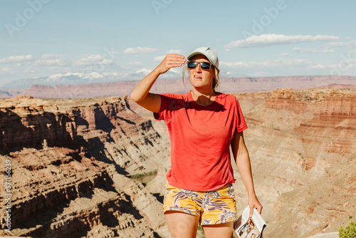 female hiker bocks sun with her hand to measure sunset time in utah photo