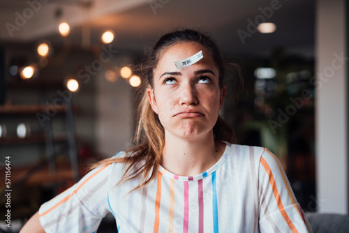 Businesswoman with to do list paper on head in office