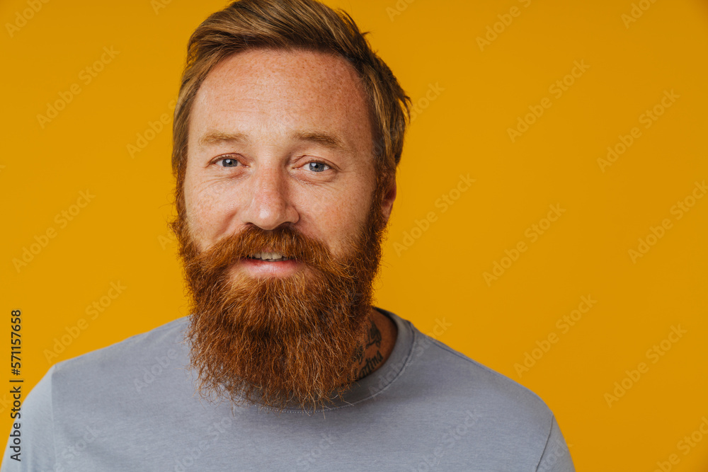 Fototapeta premium Bearded man posing at camera while standing isolated over background