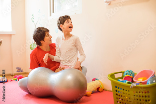 Physical therapist and girl with disability playing in rehabilitation centre