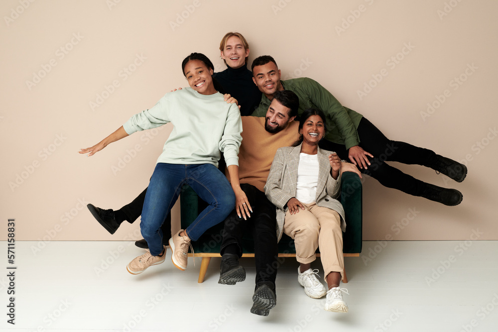 Cheerful business colleagues having fun sitting on chair in front of wall Cheerful business colleagues having fun sitting on chair in front of wall