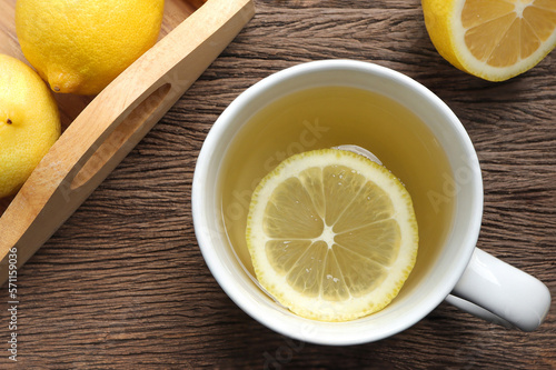 Top view of Cup of tea and fresh lemon on a wooden board.