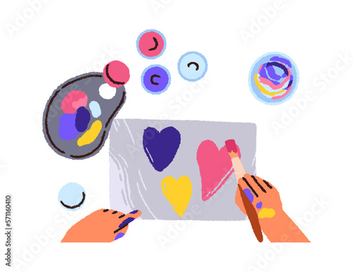 Hand with brush drawing heart on paper with gouache paint, palette, top view....