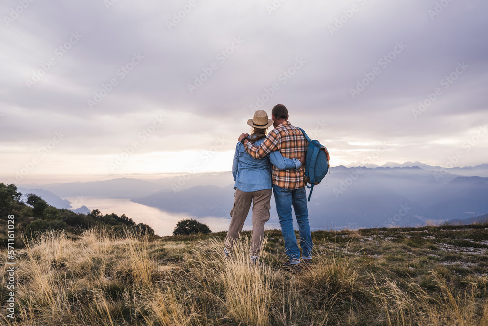 Loving couple standing with arms crossed on mountain Loving couple standing with arms crossed on mountain