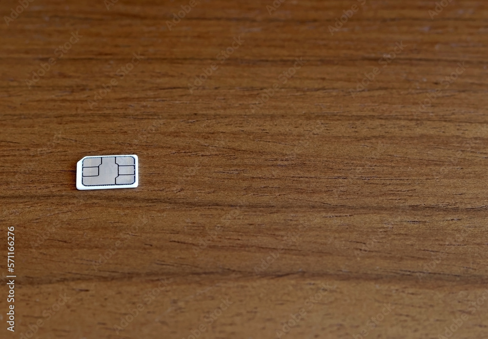 A mini, micro, nano SIM mobile phone card on a wooden table