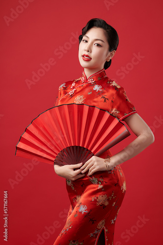 Asian chinese woman in traditional cheongsam qipao dress on red background. Chinese new year festival,