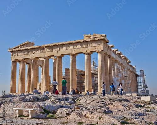 Tourists admiring Parthenon, the famous ancient Greek temple on the acropolis of Athens, Greece. Cultural travel in Athens, Greece.