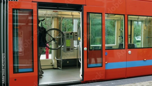 Wide shot man carrying bike onto street car photo