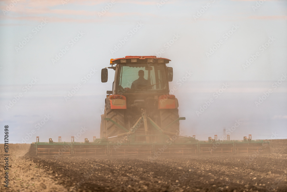 Fototapeta premium The promise of spring, tractor readying the fields for a new season of growth
