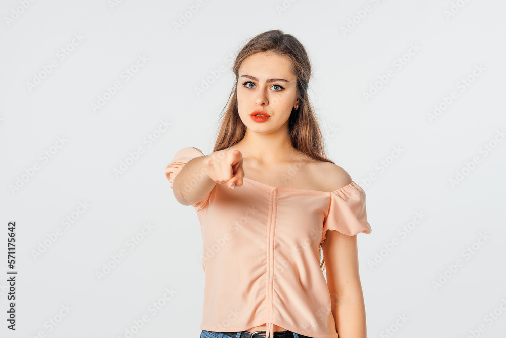 Hey, You. Angry Serious brunette woman pointing finger at camera, blaming you. Indoor studio shot on white background Hey, You. Angry Serious brunette woman pointing finger at camera, blaming you. Indoor studio shot on white background