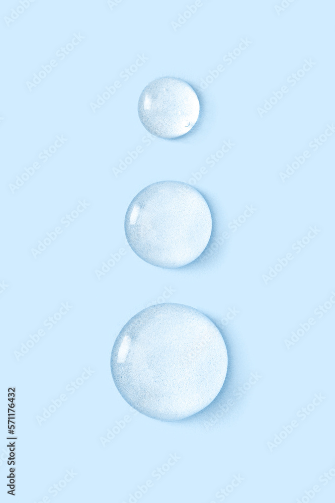 round drops of transparent gel serum on blue background round drops of transparent gel serum on blue background