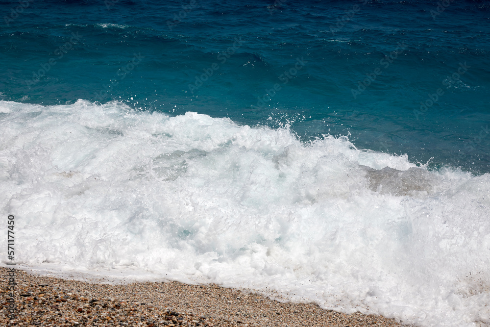 waves of the sea breaking on the shore with foam