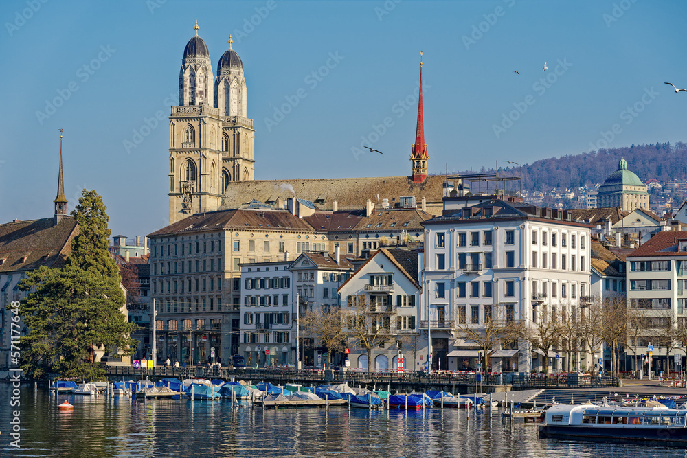 Scenic view of Limmat River with Minster Bridge and the skyline of the old town of City of Zürich with church Great Minster on a sunny winter day. Photo taken February 9th, 2023, Zurich, Switzerland.