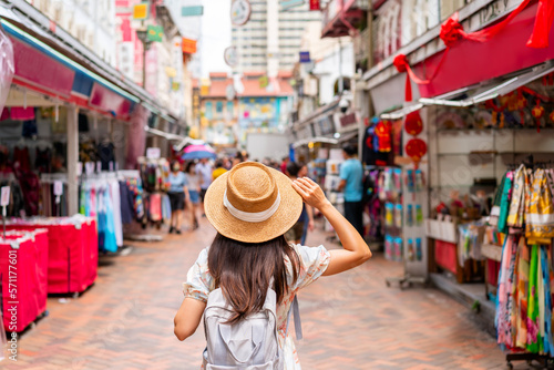 Young female tourist walking in Chinatown street market in Singapore photo