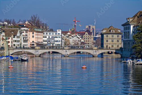 Scenic view of Limmat River with Minster Bridge and the skyline of the old town of City of Zürich on a sunny winter day. Photo taken February 9th, 2023, Zurich, Switzerland.