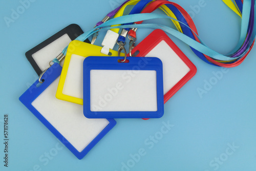 Heap of many blank badges with ropes on blue background, Accreditation and access concept. Copy space for text.