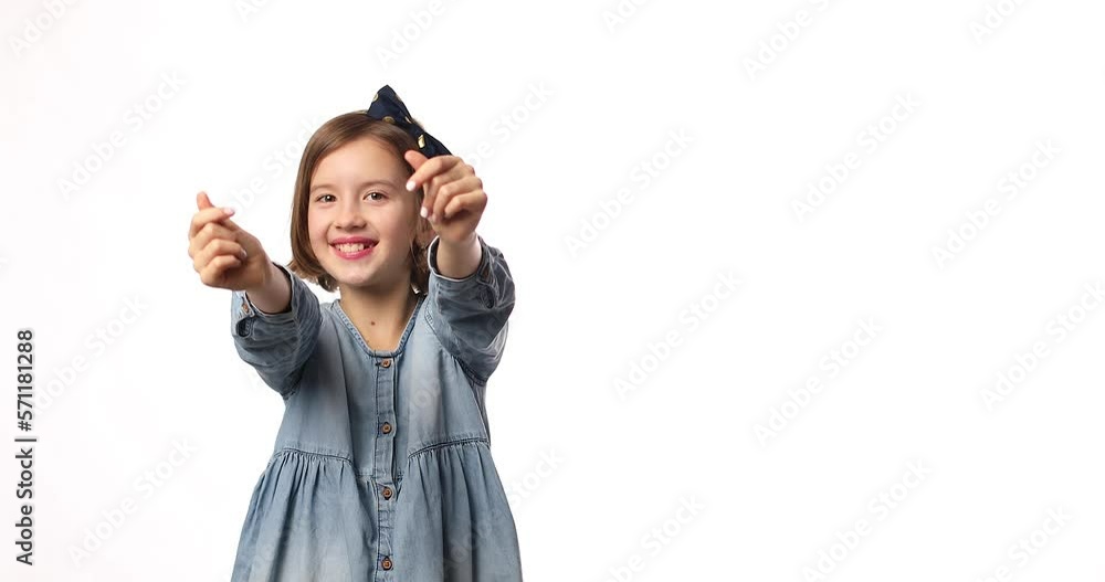 Smiling little girl make different heart signs with hands in casual denim dress isolated on white background, studio, makes love icon, gesture with fingers Heart symbol, love concept. Smiling little girl make different heart signs with hands in casual denim dress isolated on white background, studio, makes love icon, gesture with fingers Heart symbol, love concept.