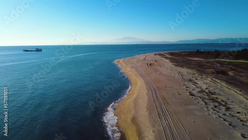 Aerial of beautiful coastline and ferry boat travelling at sea. Keramoti, Greece. photo