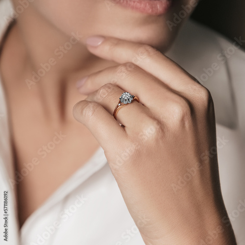 Woman Jewelery concept. Woman hands close up wearing rings, earrings and necklace modern accessories elegant life style.